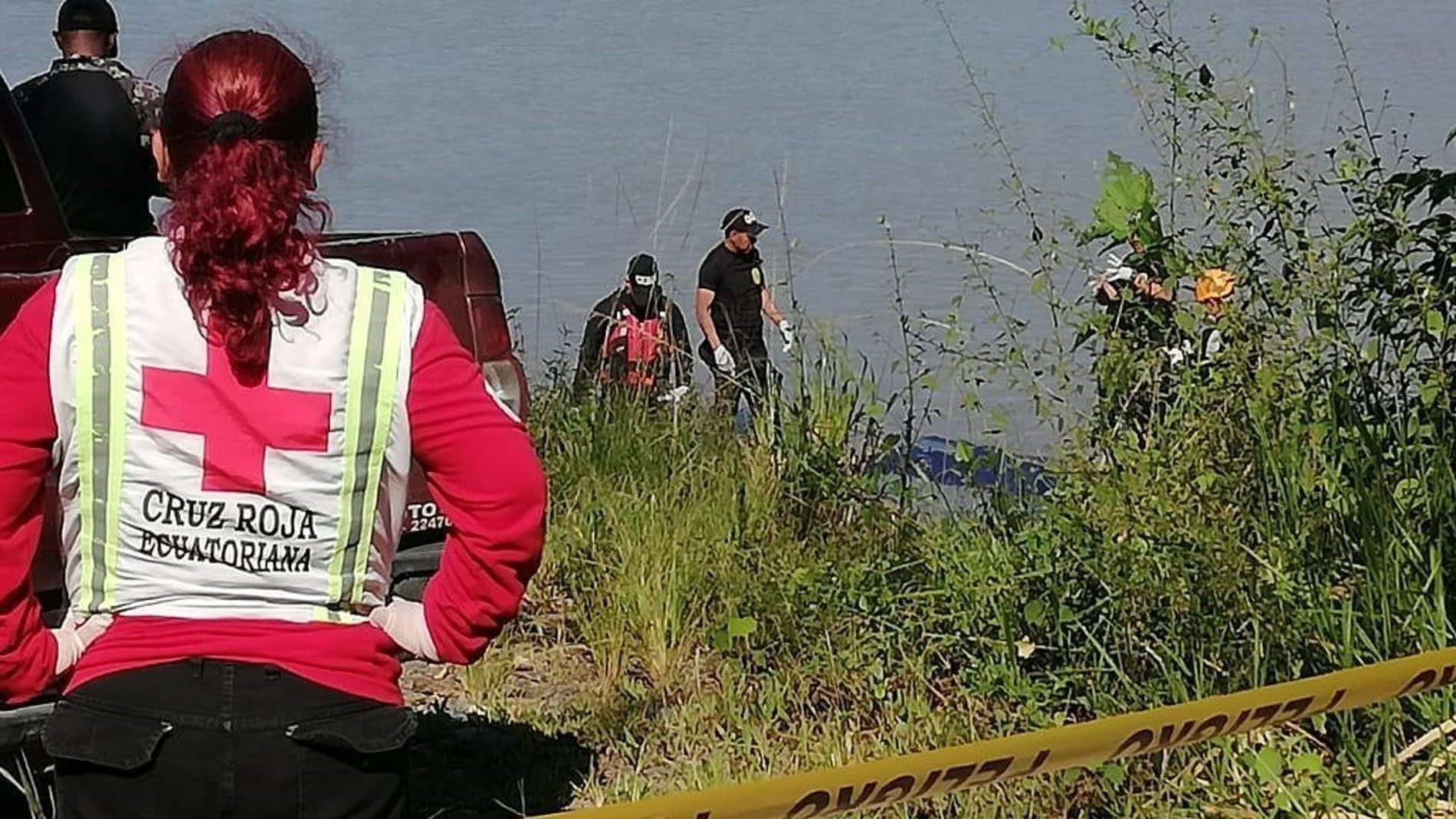 Miembros de la Cruz Roja ecuatoriana retiran el cuerpo del río