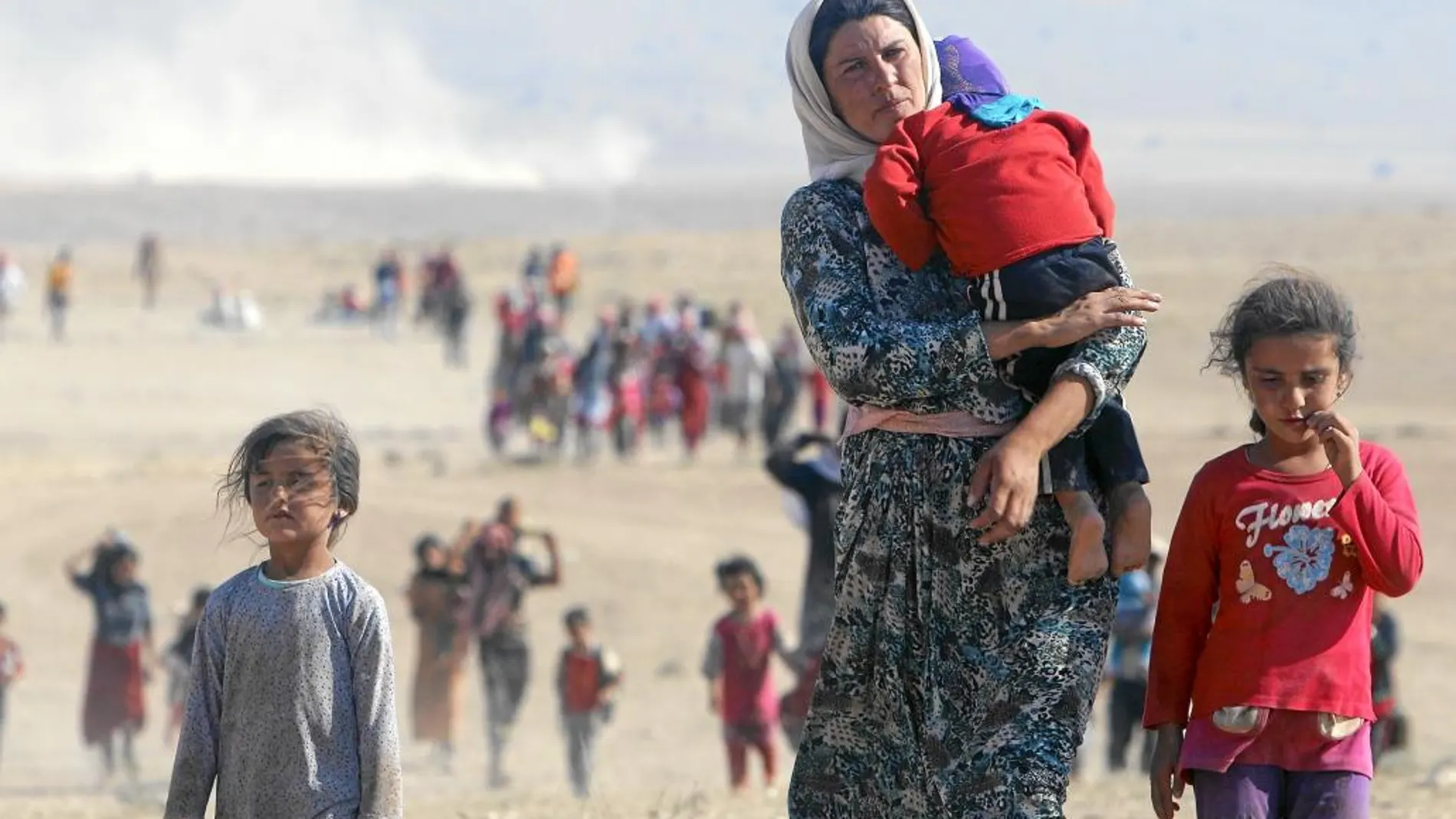 Una familia que pertenece a la minoría yazidí huye de Estado Islámico, que ha tomado el control de la ciudad de Sinjar