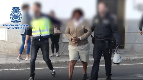 Imagen de dos agentes custodiando a la mujer que captó a su hija