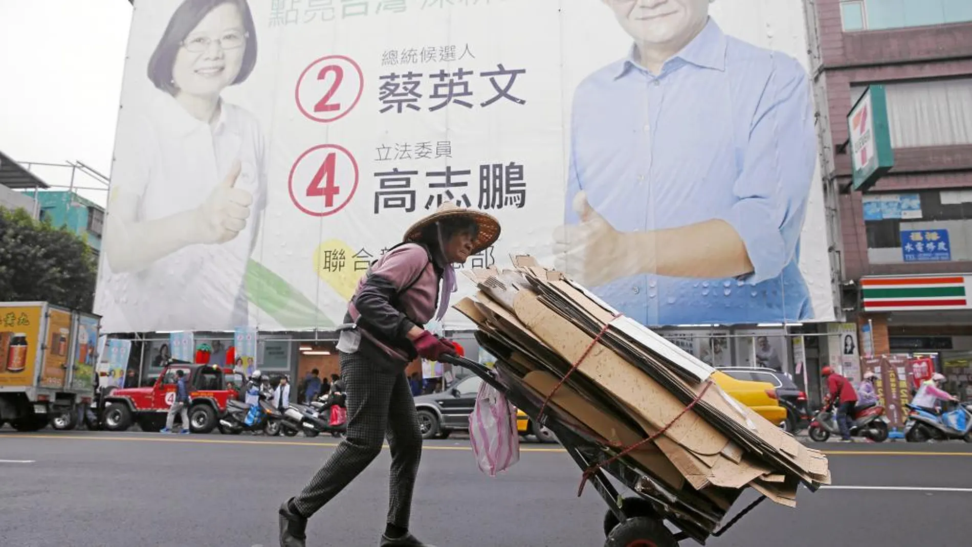 Un taiwanés camina frente a un cartel electoral de la favorita en las presidenciales, Tsai