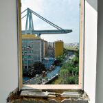 A través de la ventana de esta casa  genovesa se ve lo que aún queda en pie del puente Morandi, cuya construcción se derrumbó el  pasado verano.