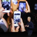 Consumidores con su móvil en un acto de Apple
