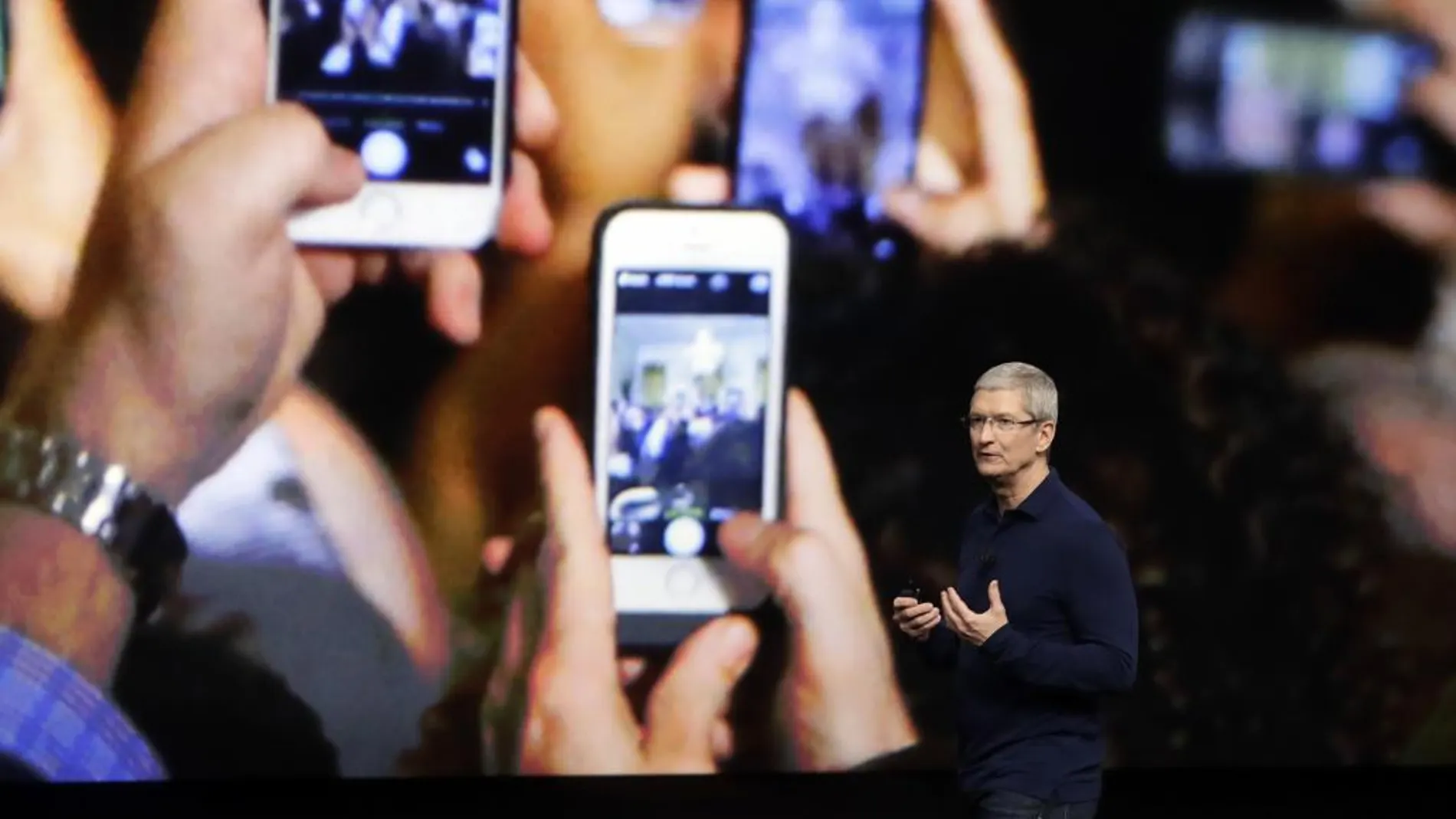 Consumidores con su móvil en un acto de Apple