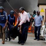 Rescatadores y periodistas evacuando a un hombre herido tras el atentado en Nairobi, Kenia, el pasado 15 de enero