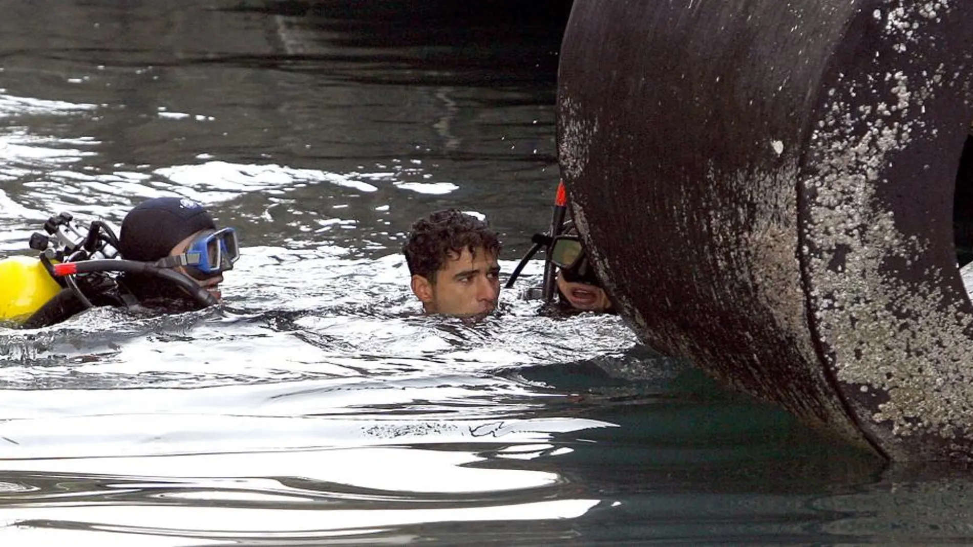 Imagen de archivo de un joven inmigrante tras saltar del barco que une Melilla con Málaga