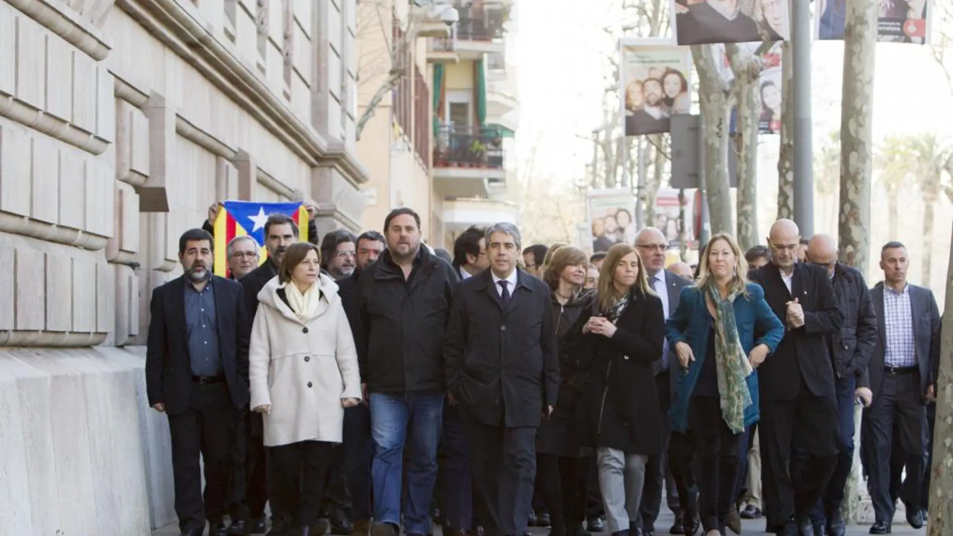 Homs (c), arropado por ciudadanos y miembros del Govern y dirigentes de ERC y CDC, a su llegada al Tribunal Superior de Justicia de Cataluña