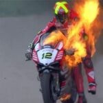 Xavi Forés sujetando su moto en llamas