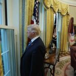Donald Trump mira por una ventana del despacho oval