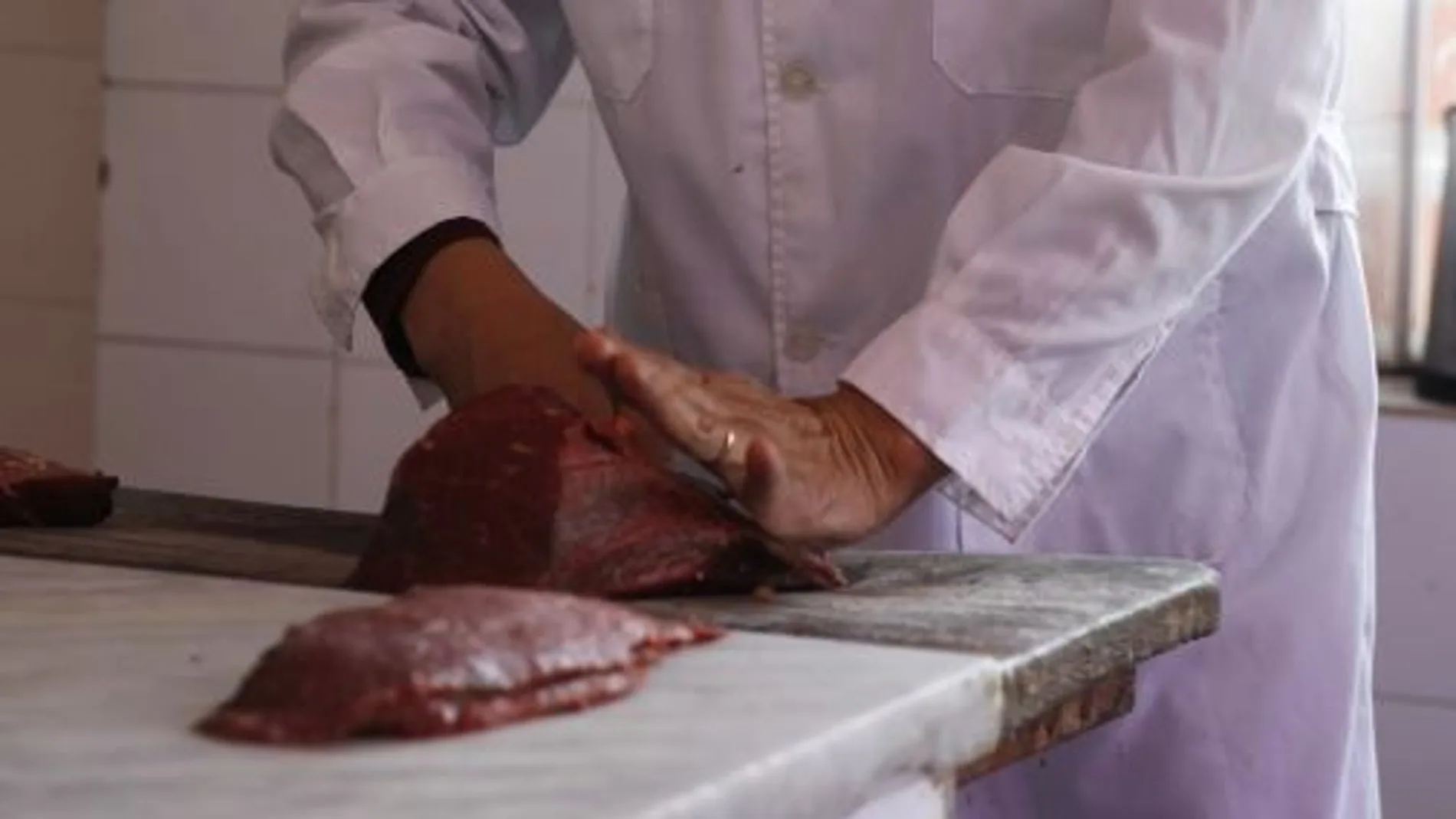 El presidente de la Unión de Vendedores de Carne de Uruguay mientras realiza cortes de bife en su carnicería en Montevideo