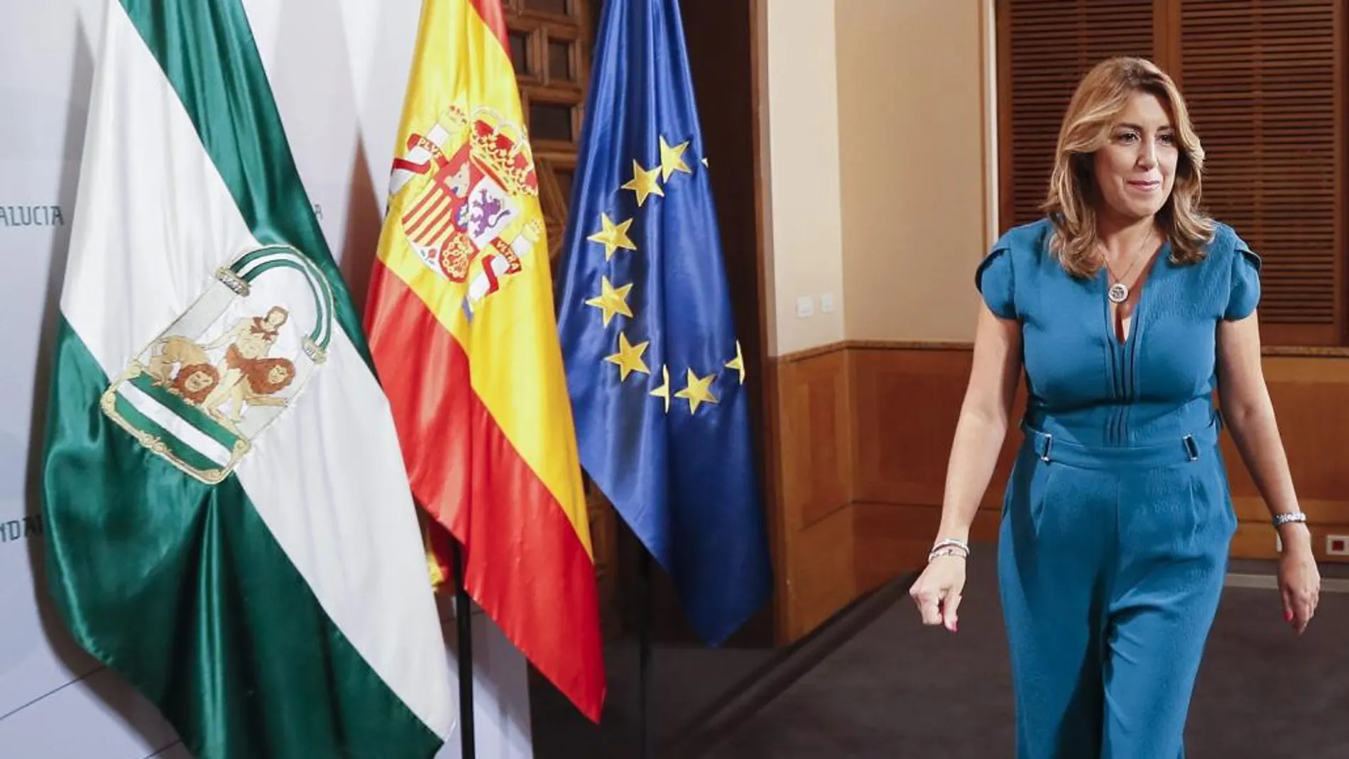 La presidenta de la Junta, Susana Díaz, pasa junto a las banderas andaluza, española y europea