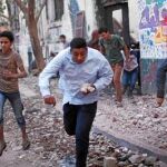 Un manifestante egipcio arroja piedras durante los enfrentamientos con la Policía, ayer, en la plaza Tahrir