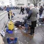 Una mujer socorre a uno de los heridos en el atentado de Londres