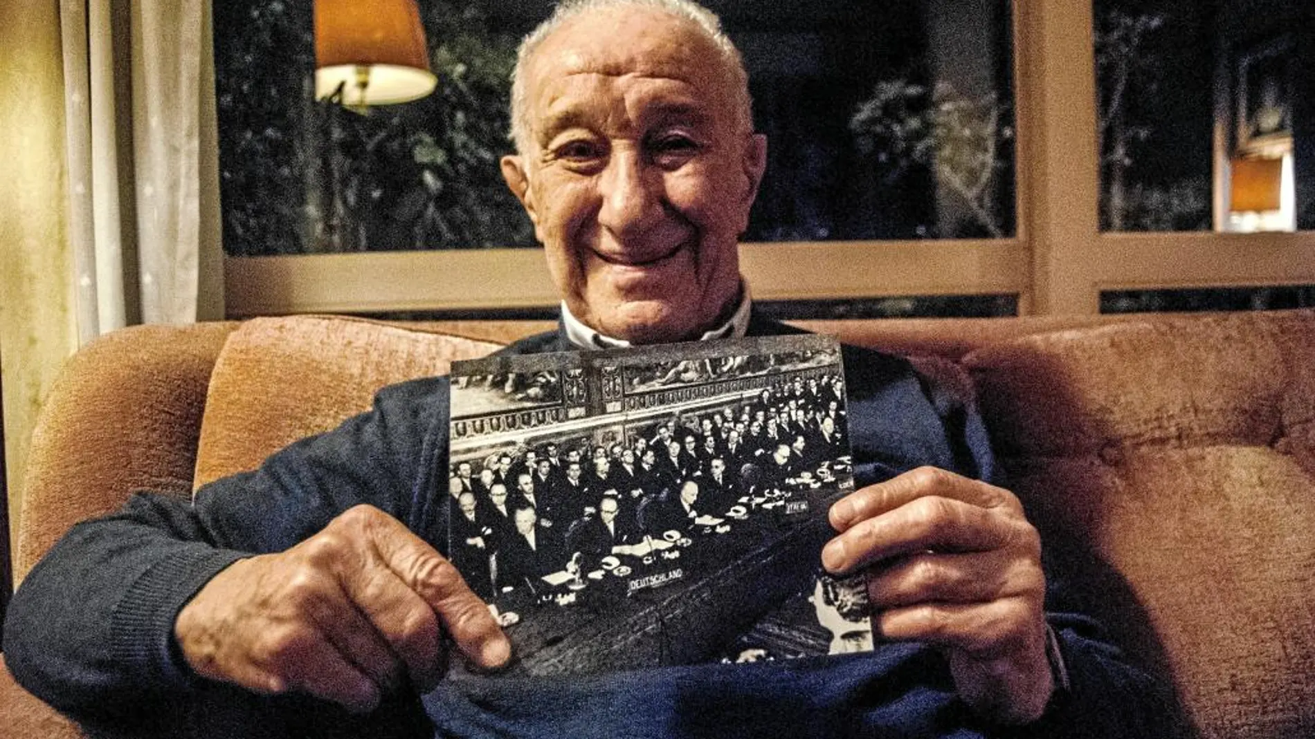 Achille, de 90 años, posa con la foto de la firma durante la entrevista con LA RAZÓN, en Roma