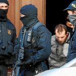 Uno de los 17 detenidos en la «operación Alexandria», en el momento de ser sacado de su domicilio por los agentes de los Mossos de Esquadra y conducido a un vehículo oficial para su traslado