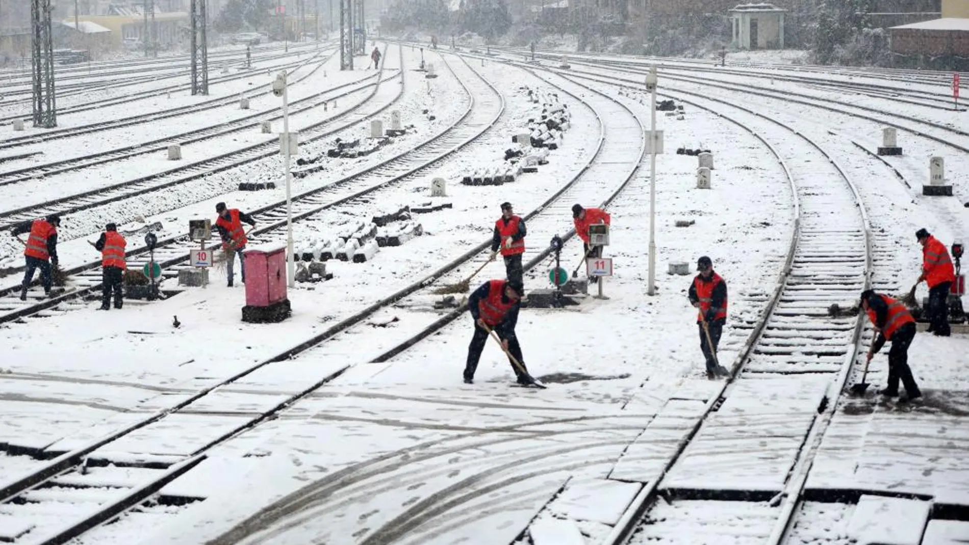Trabajadores retiran la nieve de las vías del tren en la ciudad china de Nanchang