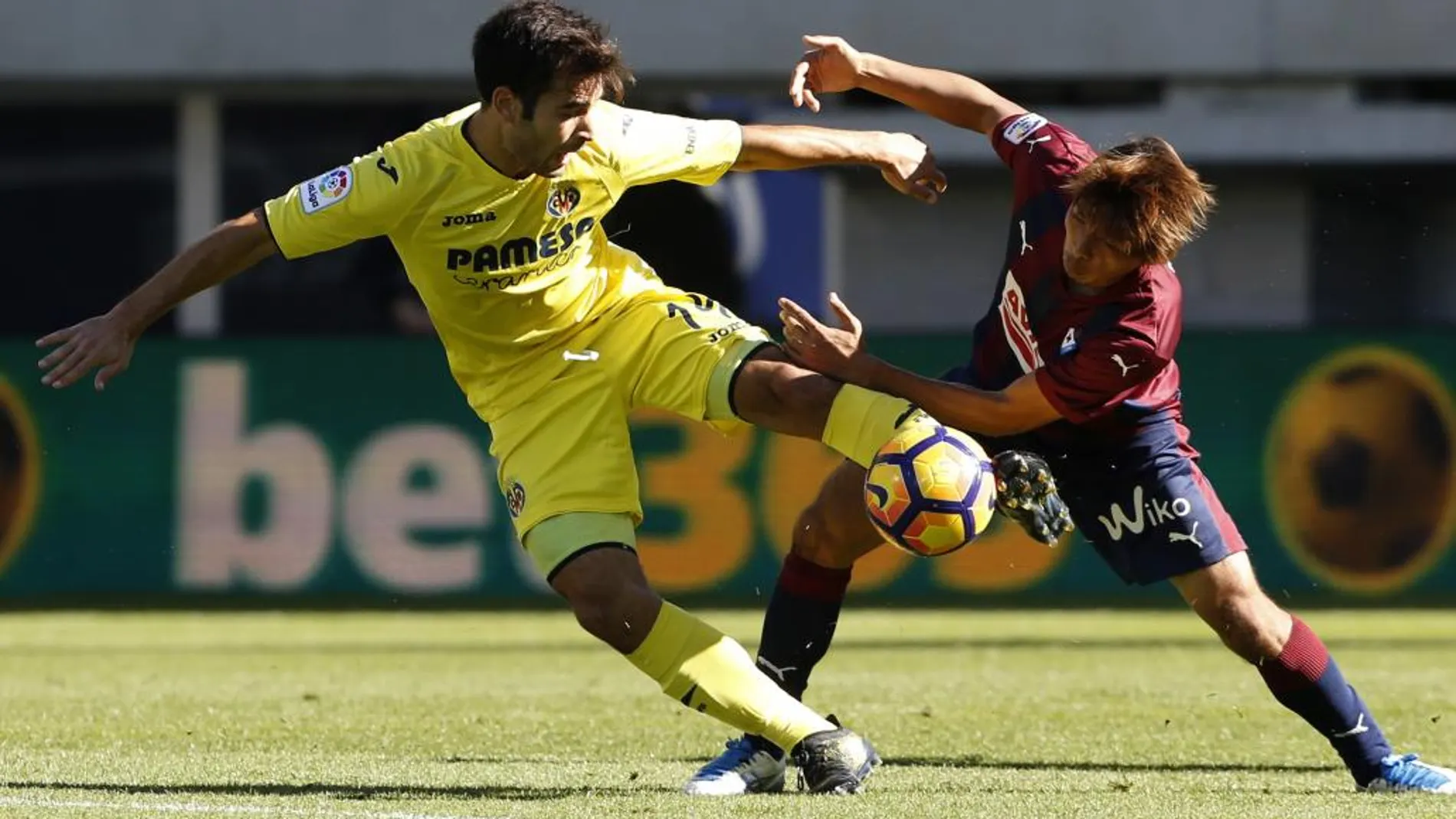 El centrocampista japonés del Eibar Takashi Inui (d) lucha un balón con el centrocampista del Villarreal Manu Trigueros (i).