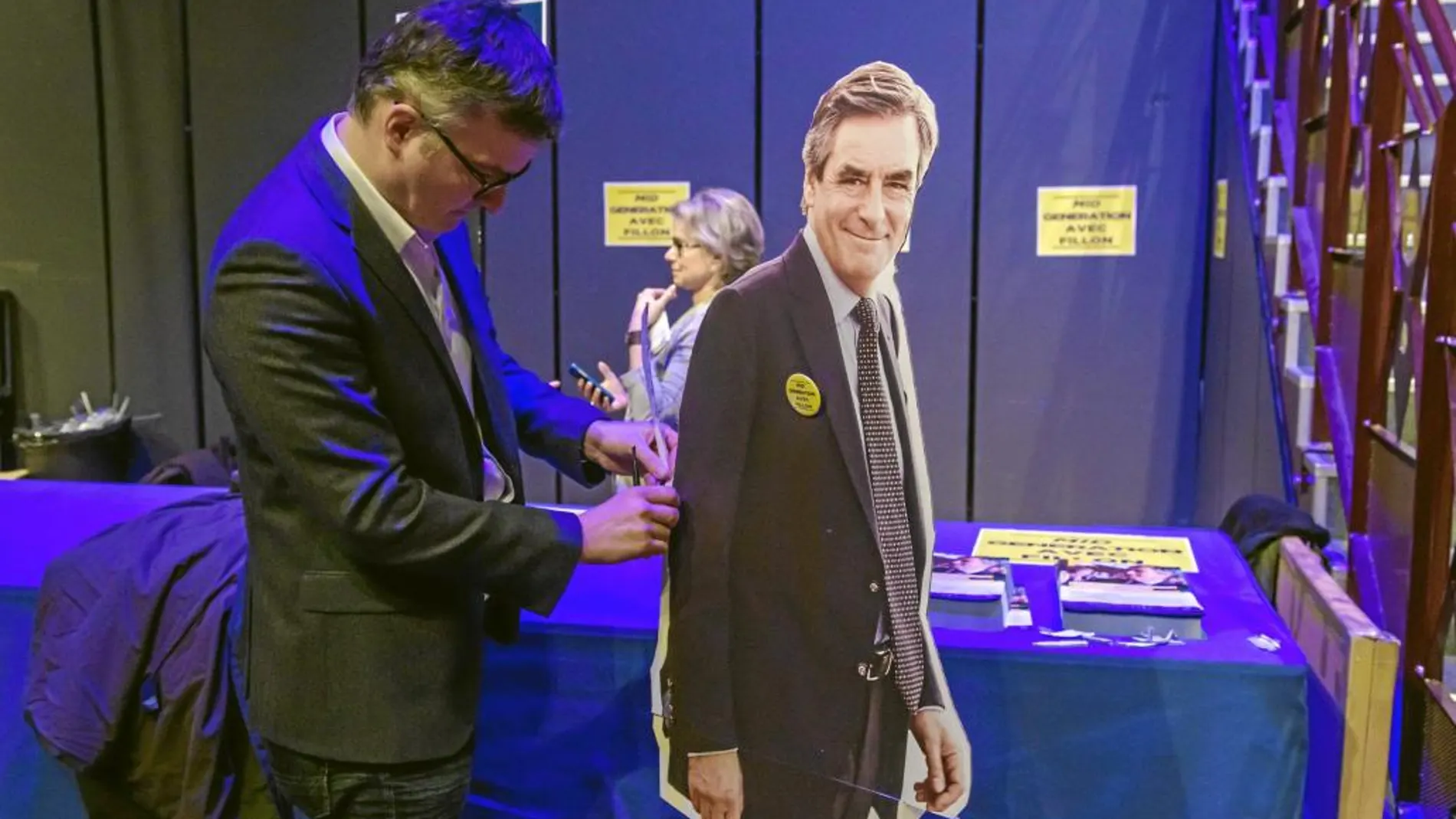 Un simpatizante de François Fillon prepara una imagen en cartón del candidato antes de un mitin en Aubervilliers