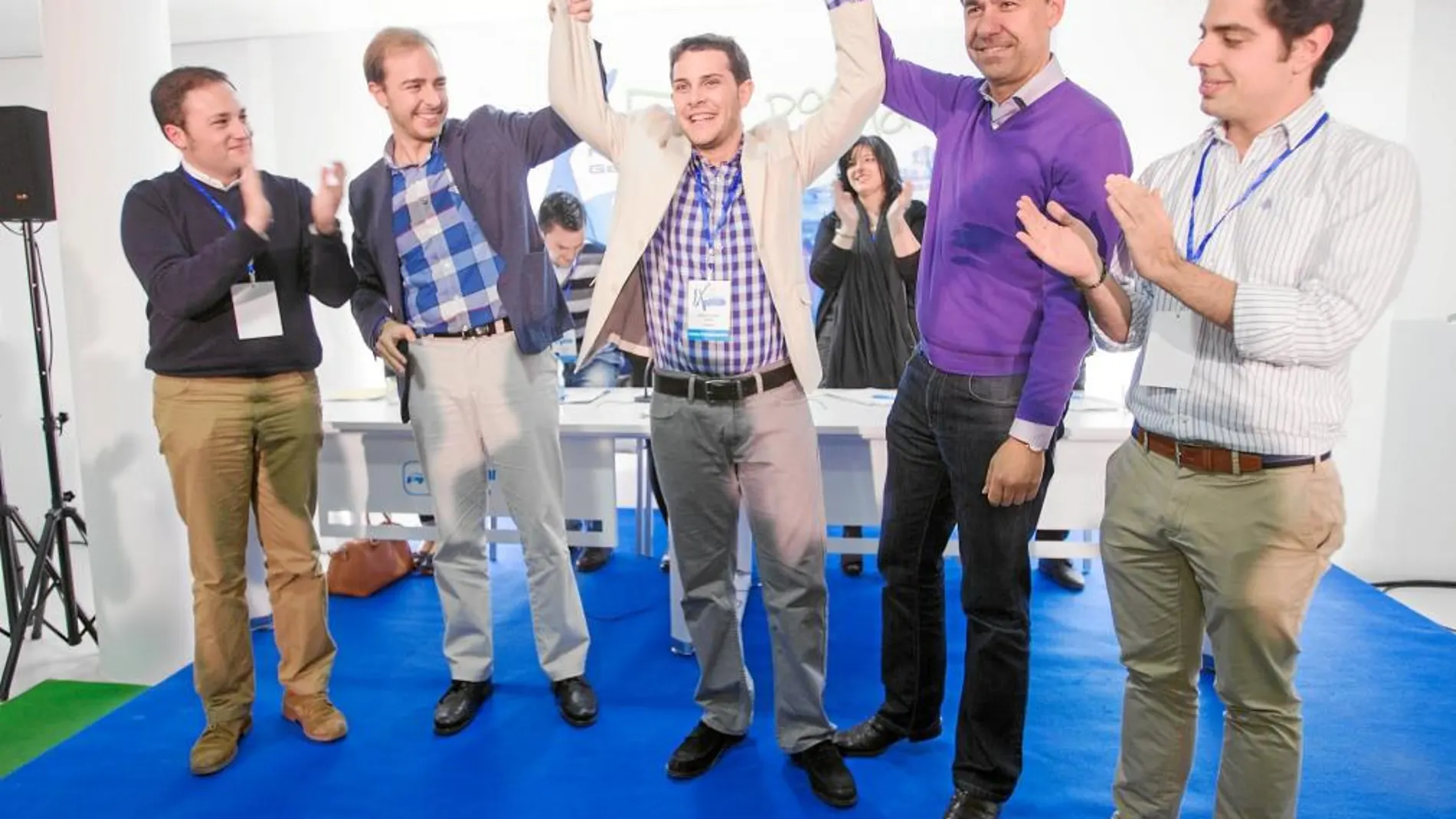 Martínez Maíllo y Javier Dorado levantan los brazos de Víctor López, tras ser reelegido por unanimidad como presidente de NNGG del PP de Zamora, en presencia también de Eduardo Carazo.
