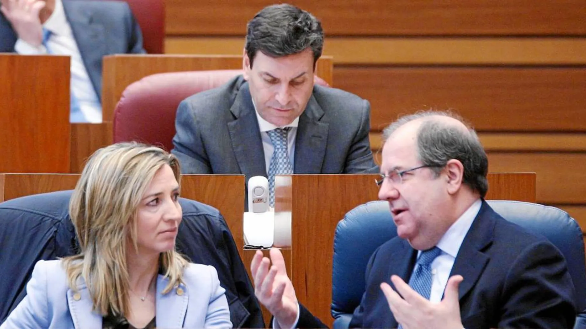 Juan Vicente Herrera dialoga en las Cortes con Alicia García, cuya consejería de Familia e Igualdad de Oportunidades impulsa este servicio integral. Al fondo, el consejero Carlos Fernández Carriedo.