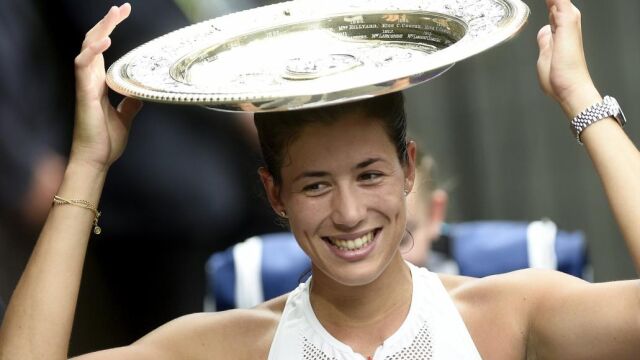 Muguruza celebra con el trofeo su victoria en Wimbledon