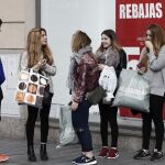 Un grupo de jóvenes, en el exterior de un comencio del centro de Pamplona donde las rebajas de invierno han comenzado.