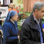 Leopoldo Barrera, cabeza del PP por Vizcaya, al ir a votar, mientras apoderados de Bildu muestran una bandera a favor del acercamiento de presos de ETA