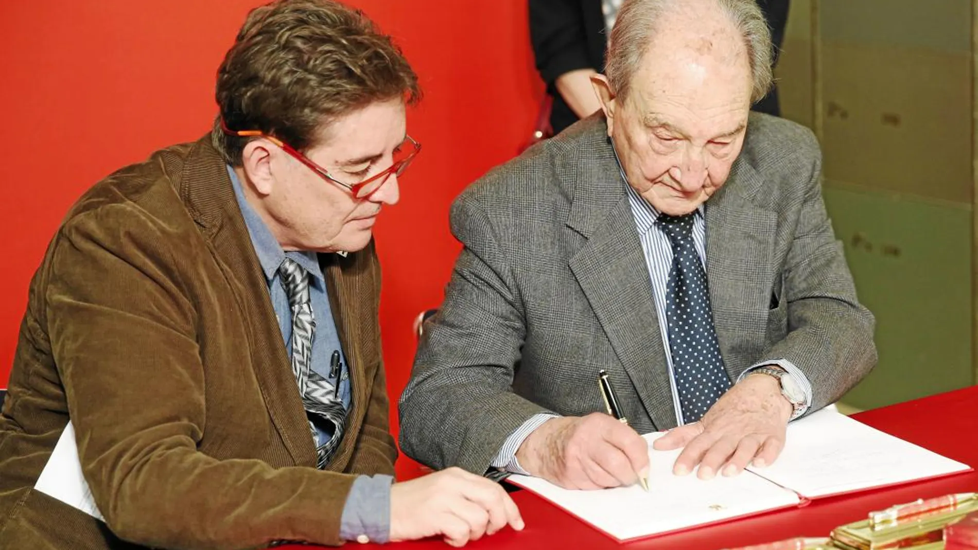 Sánchez-Albornoz (dcha.) firma el libro de honor junto a García Montero