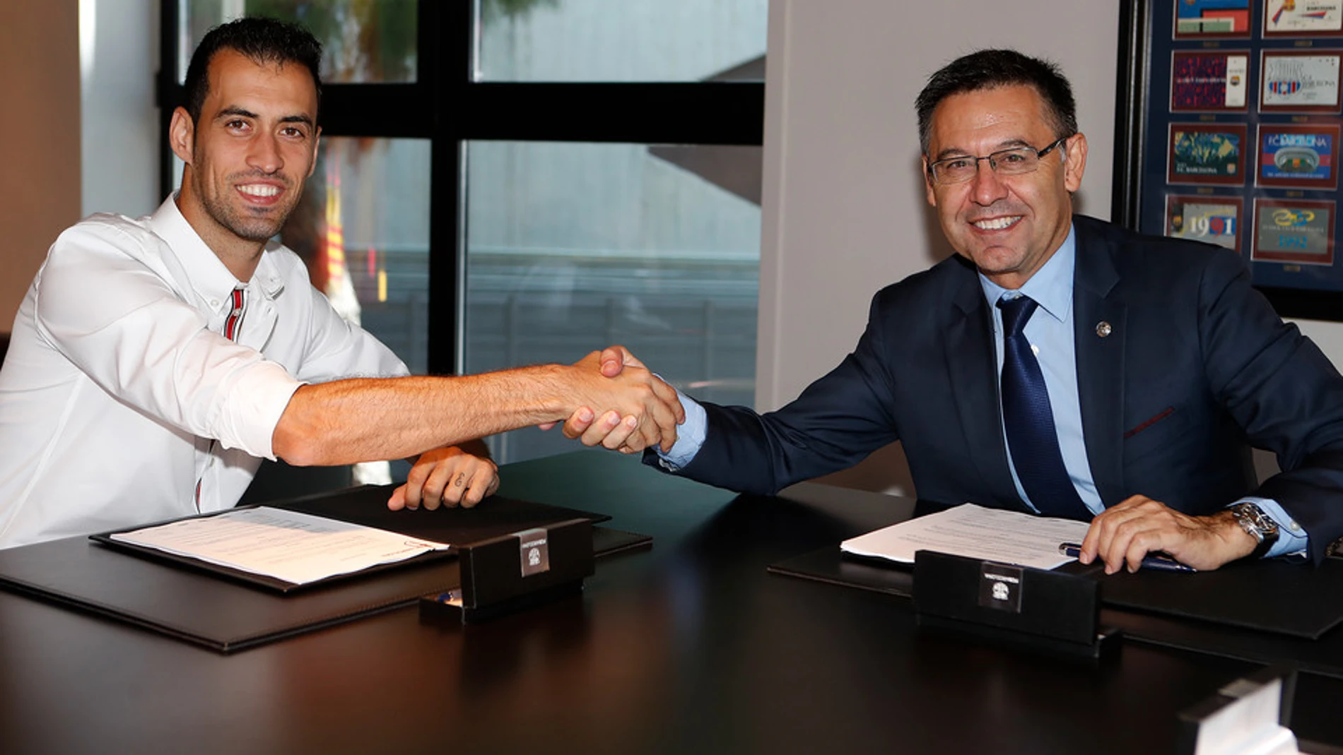 Sergio Busquets, en el momento de firmar su renovación junto al presidente culé, Josep María Bartomeu / FCB