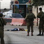 Soldados y policías israelíes junto al cuerpo de un palestino que apuñaló a un israelí en Cisjordania