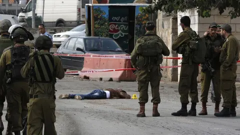 Soldados y policías israelíes junto al cuerpo de un palestino que apuñaló a un israelí en Cisjordania