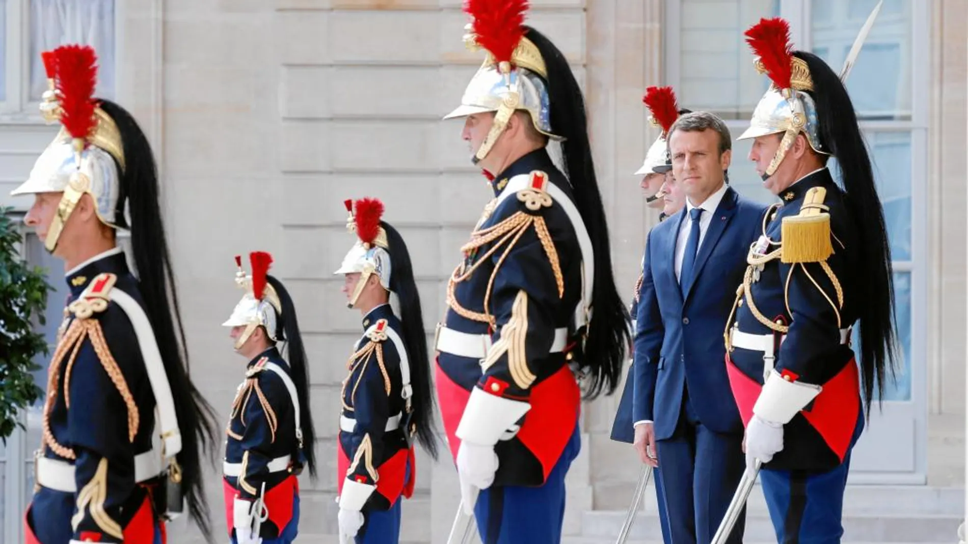 El presidente de la República francesa, Emmanuel Macron, rodeado de la guardia presidencial, ayer, en los jardines del Palacio del Elíseo
