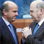 El ministro español de Economía y Competitividad, Luis de Guindos (izda.), conversa con su homólogo irlandés. Michael Noonan. al inicio de la reunión