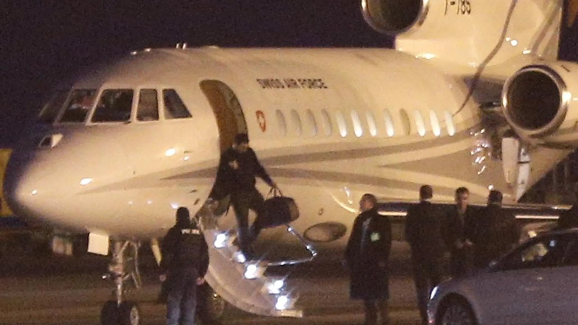 Varias personas bajan del avión suizo que ha partido de Teherán