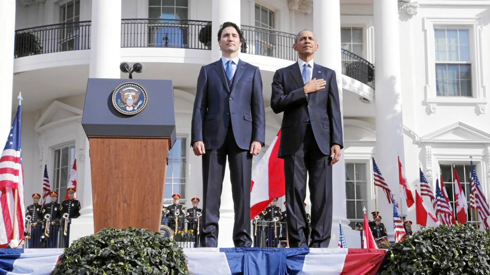Barack Obama y el primer ministro de Canadá, Justin Trudeau, escuchan el himno nacional durante su ceremonia de llegada a la Casa Blanca