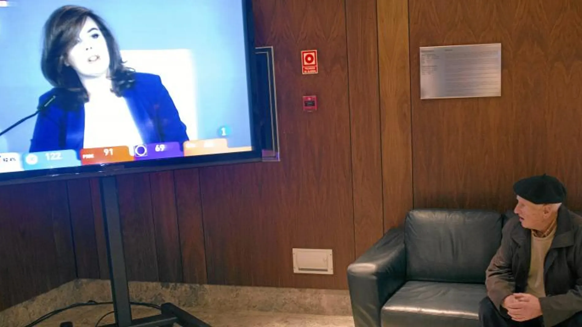 Un militante ayer en la sede del PP en Santander sigue la comparecencia de Santamaría para dar a conocer los resultados electorales