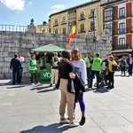  Una pareja de lesbianas se besa frente a un puesto de Vox