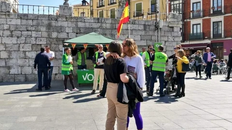 Las dos mujeres besándose frente al puesto