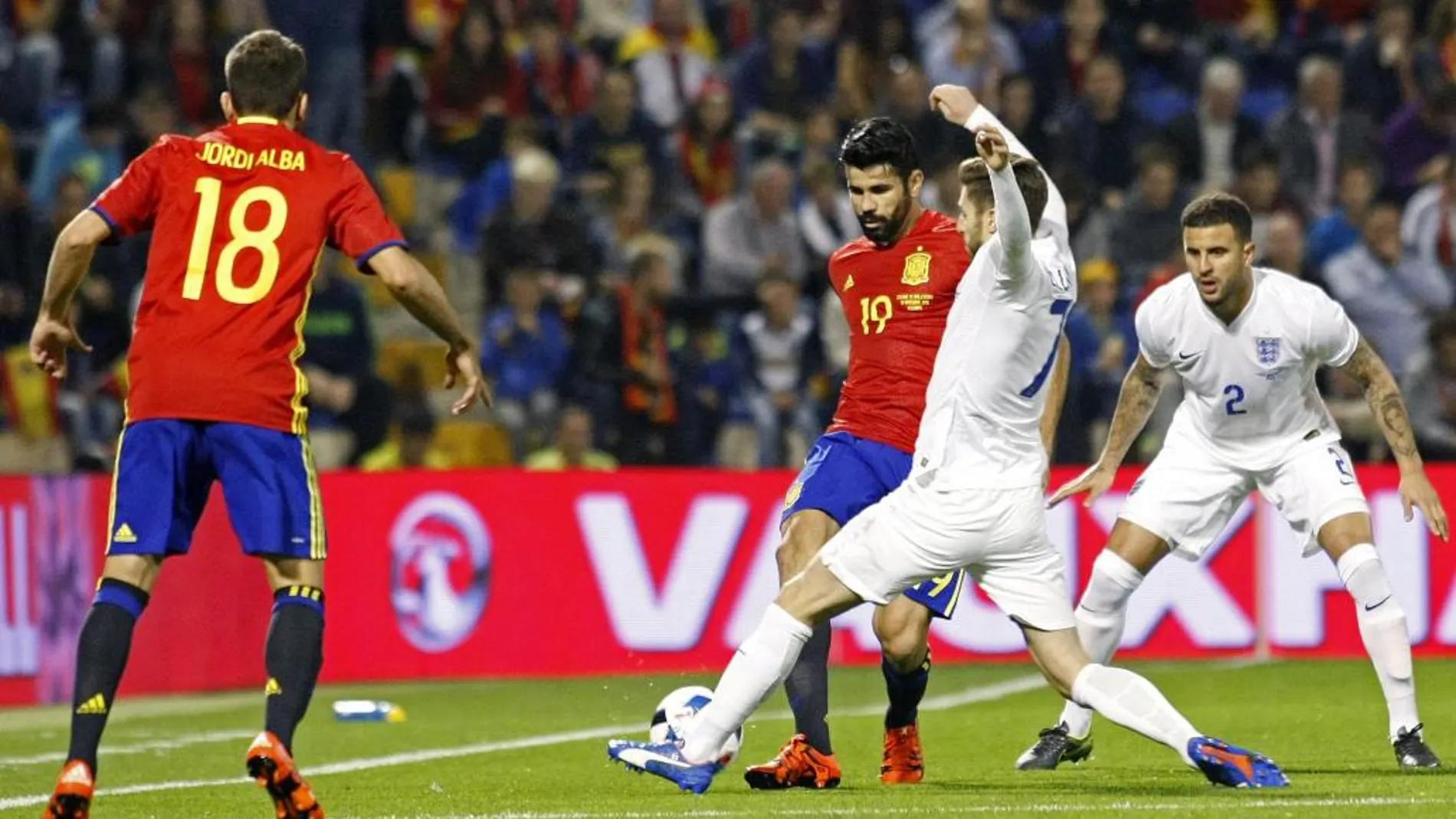 El delantero de la selección española Diego Costa (c) intenta arrebatar el balón centrocampista de Inglaterra Adam Lallana