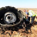 Invetigadores egipcios chequean los restos del avión caído en el desierto del Sinaí.