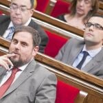 El presidente de ERC, Oriol Junqueras, observa en el Parlament, mientras Mas revisa unos papeles