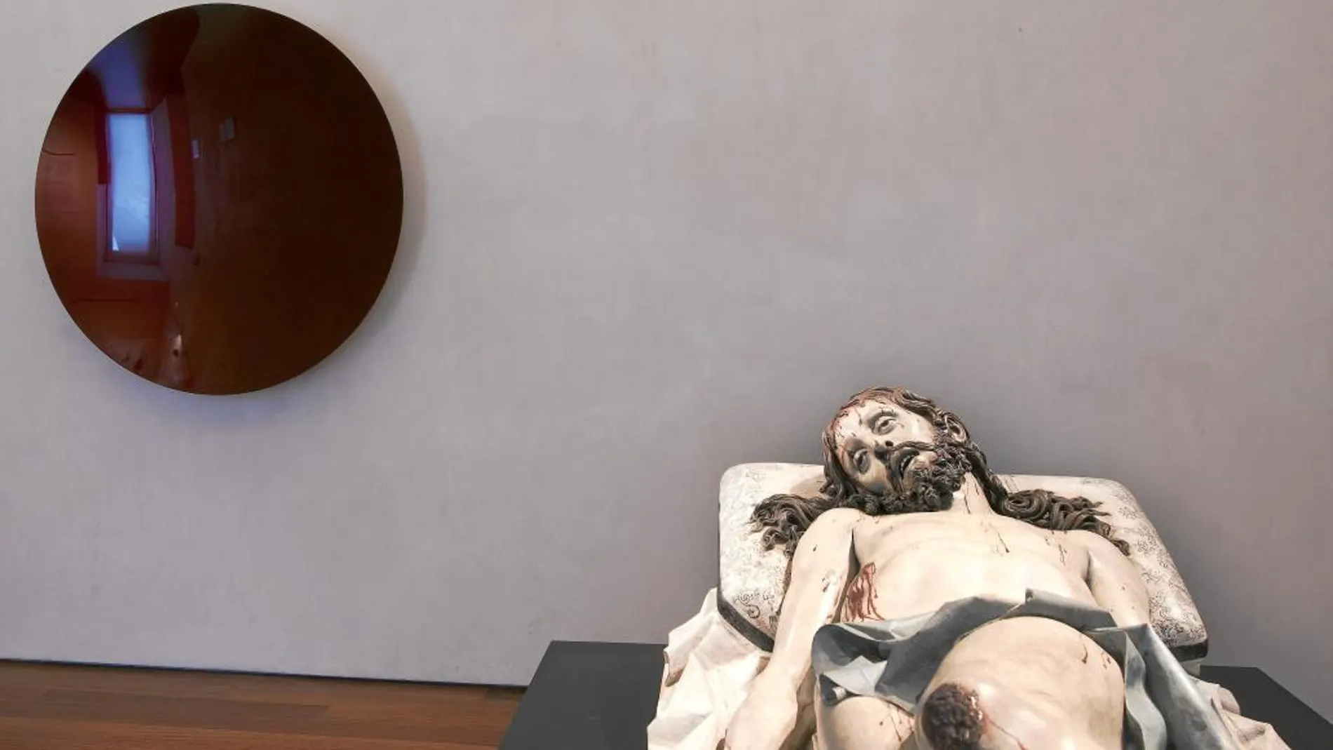 La talla del Cristo de Gregorio Fernández, del siglo XVII se refleja en el espejo cóncavo de Anish Kapoor, con el que comparte el rojo