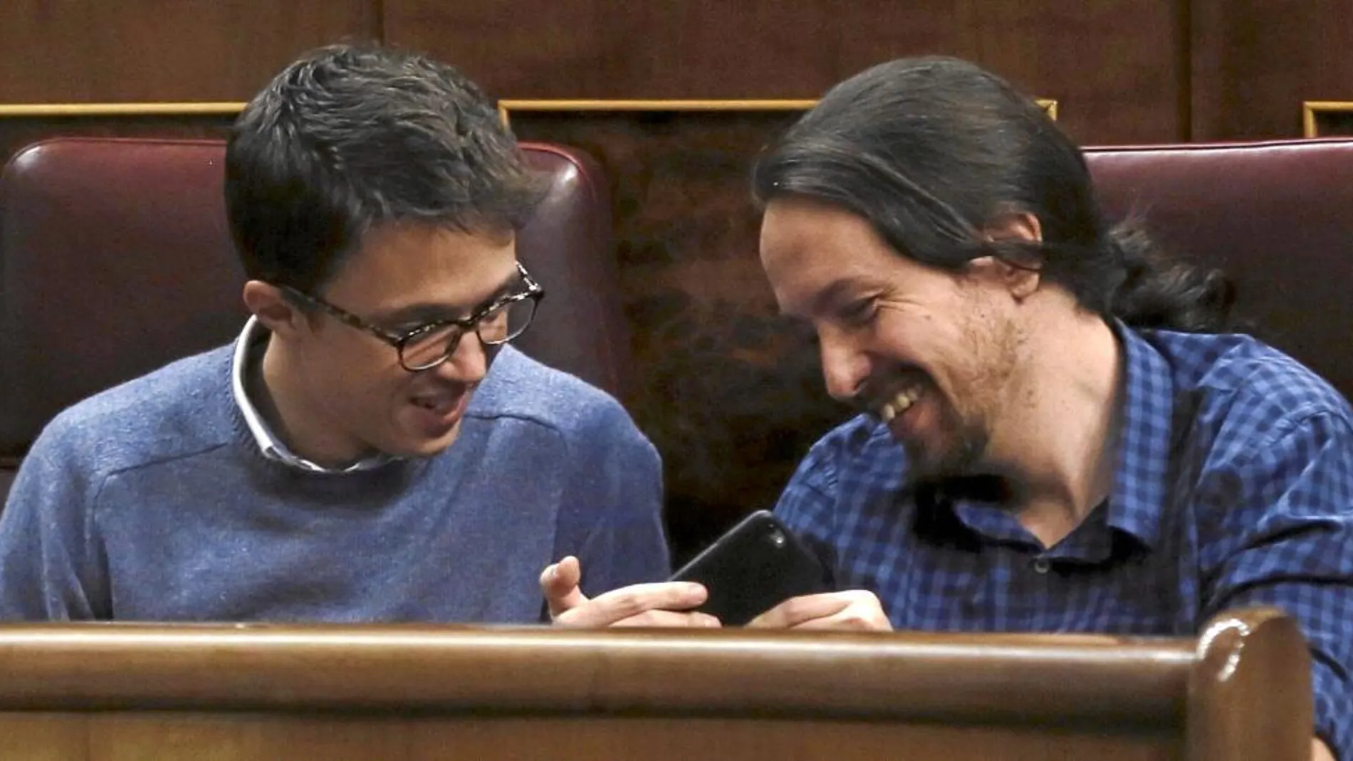 Iñigo Errejón y Pablo Iglesias bromean en sus escaños del Congreso durante el Pleno de ayer