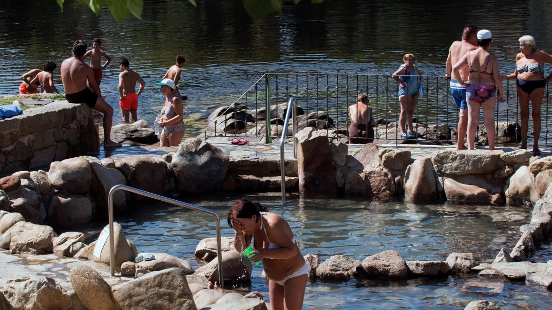 Un grupo de personas se refrescan, esta mañana, en la zona fluvial del río Miño y las termas de A Chavasqueira / Efe