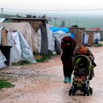 Imagen de dos mujeres con un niño en el campamento de Roj