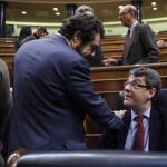 El diputado de Ciudadanos, Miguel Gutiérrez (i), conversa con el ministro de Energía, Álvaro Nadal, durante el pleno del Congreso
