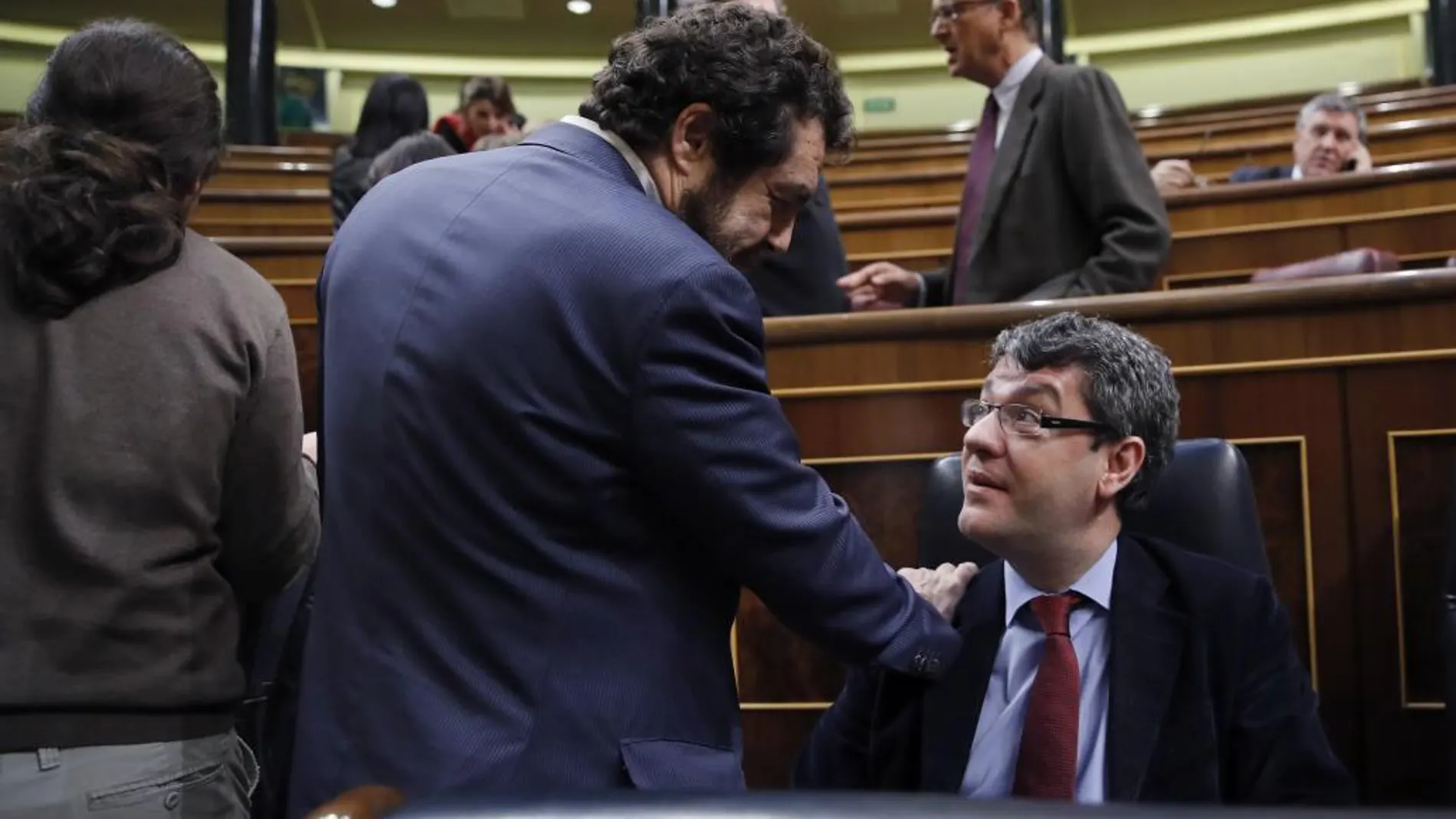 El diputado de Ciudadanos, Miguel Gutiérrez (i), conversa con el ministro de Energía, Álvaro Nadal, durante el pleno del Congreso