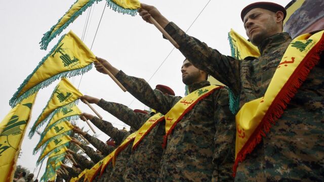 Combatientes de Hizbulá con sus banderas durante un funeral