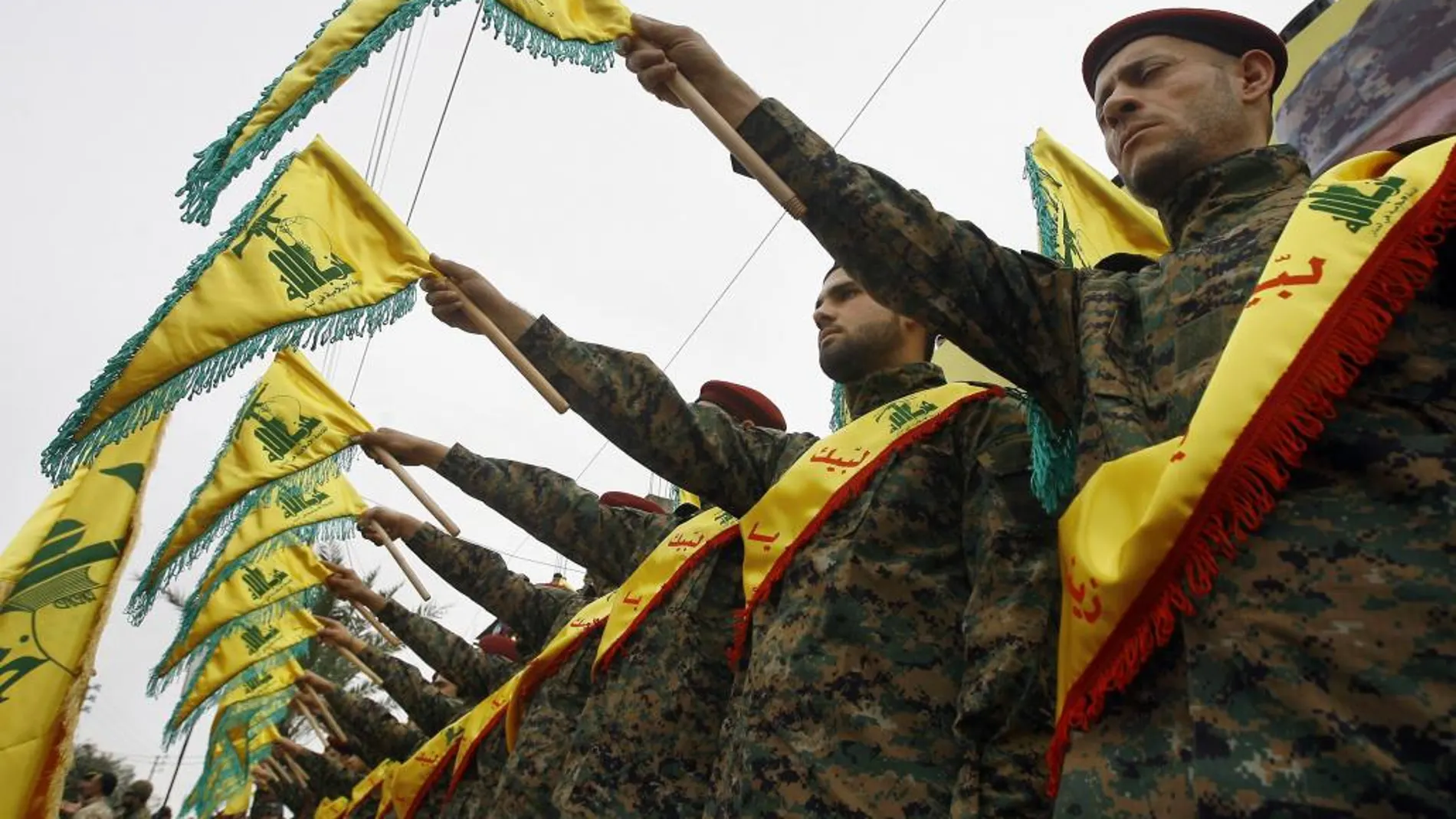Combatientes de Hezbolá con sus banderas durante un funeral