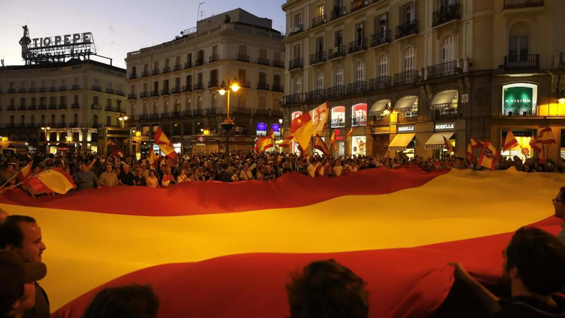 Un grupo de personas desplegó hoy una gran bandera de España en la Puerta del Sol de Madrid en una concentración convocada a través de las Redes Sociales en contra de la independencia de Cataluña