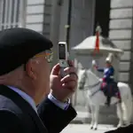 Una persona de la tercera edad hace una fotografía a un monumento